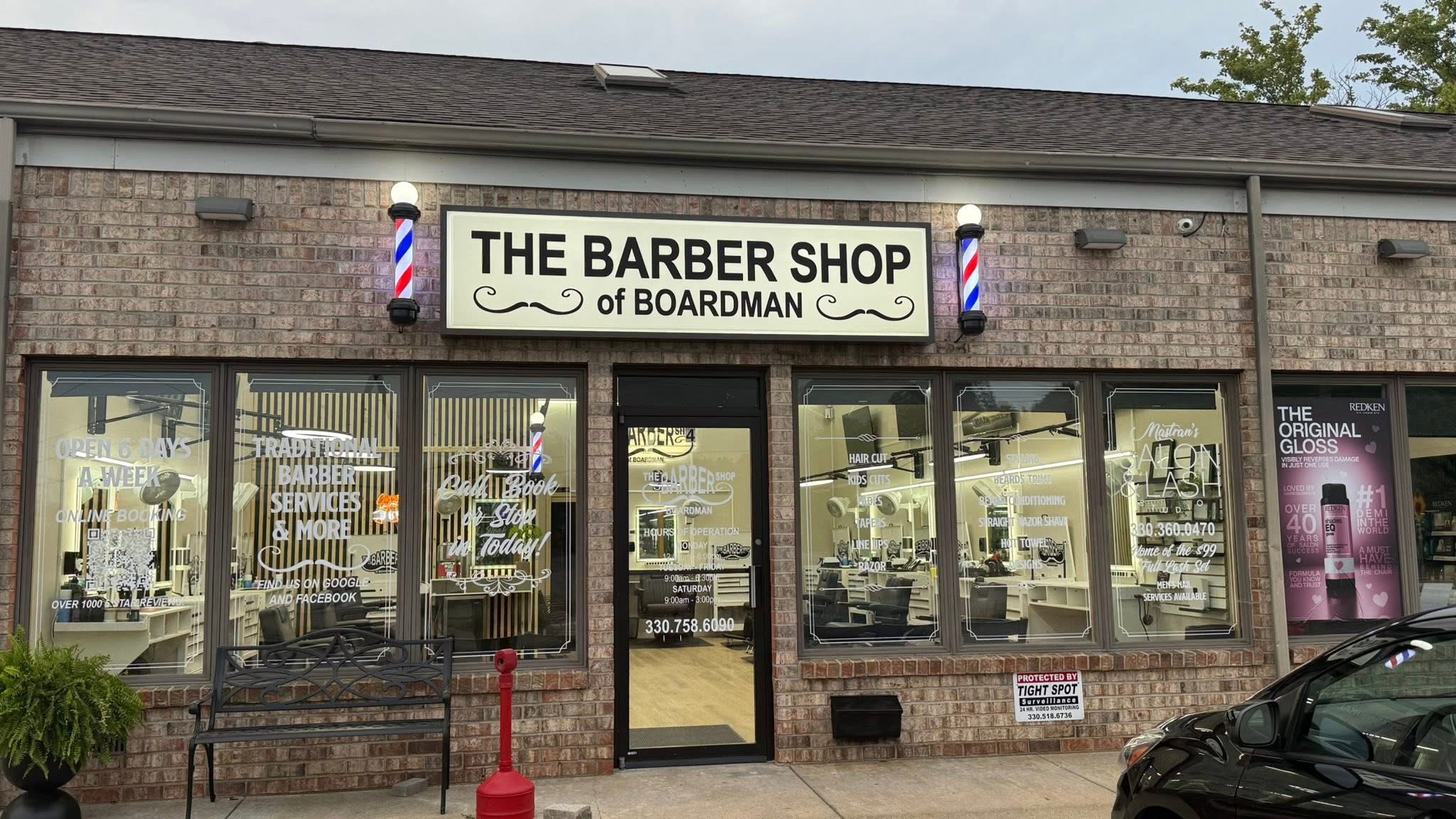 The Barbershop of Boardman storefront with its sign and barber poles